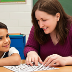 **A dedicated special education teacher warmly interacting with a young student who is engaged in a math problem, emphasizing a one-on-one personalized approach.** This image should highlight the positive relationship and customized support.